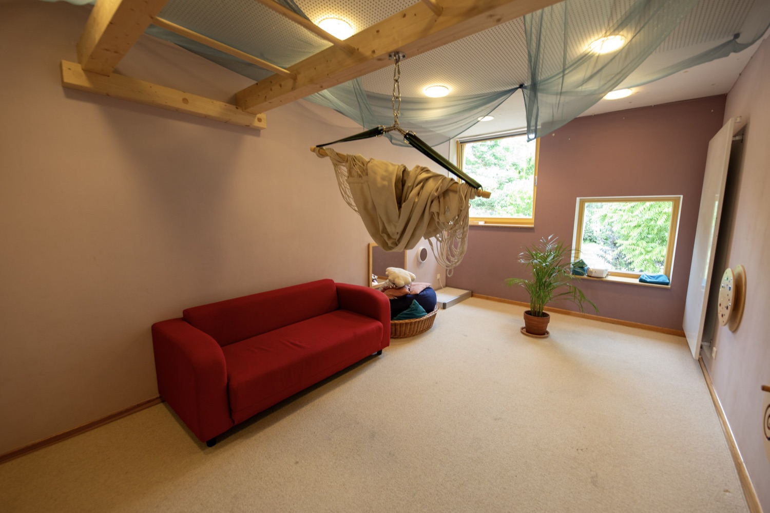 Ruheraum mit Hängematte, gemütlichem Sofa und gedämpftem Licht zum Ausruhen