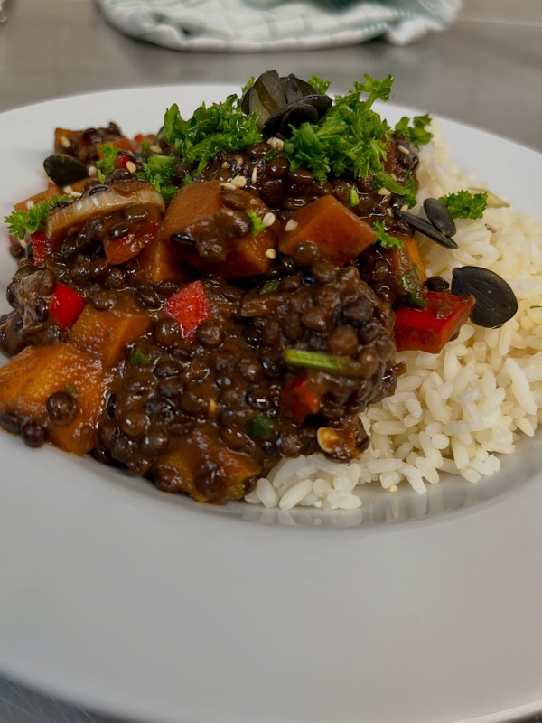 Linsen-Gemüse-Ragout mit Paprika, Kürbis, Kürbiskernen und Petersilie, dazu Reis
